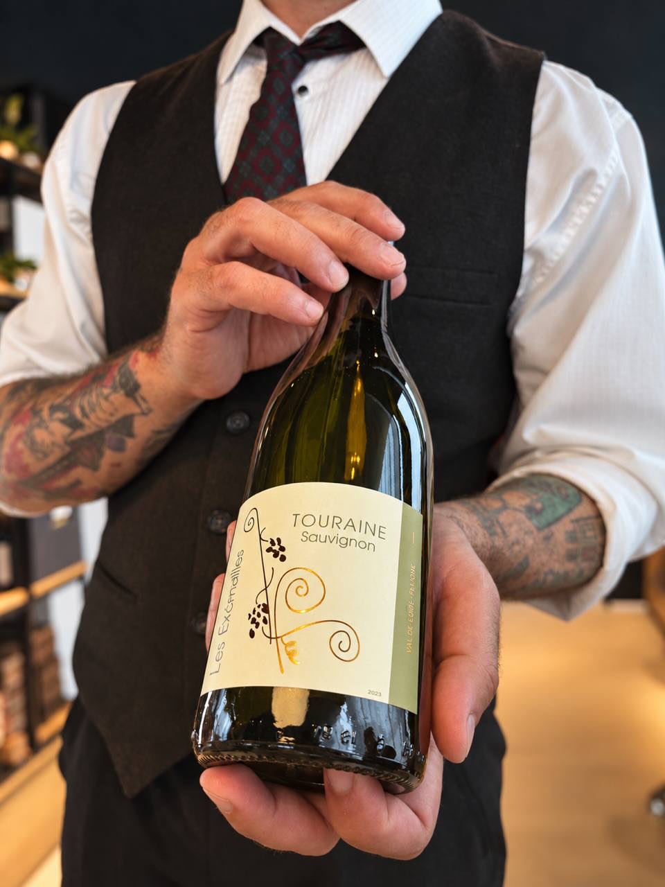 Сомелье с бутылкой Touraine Sauvignon на встрече клуба